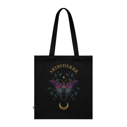 Black tote bag with a butterfly design and 'ARTBYHERRR' branding on a black background